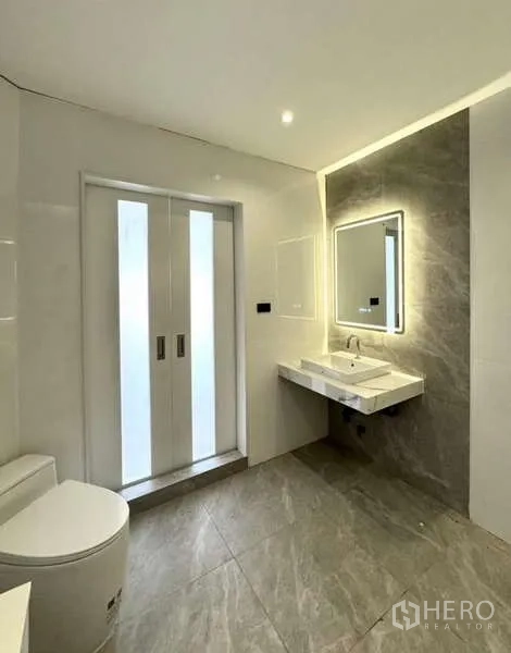 联排别墅 出租或出售在Prawet, Bangkok - 明亮浴室，背光镜与磨砂推拉门