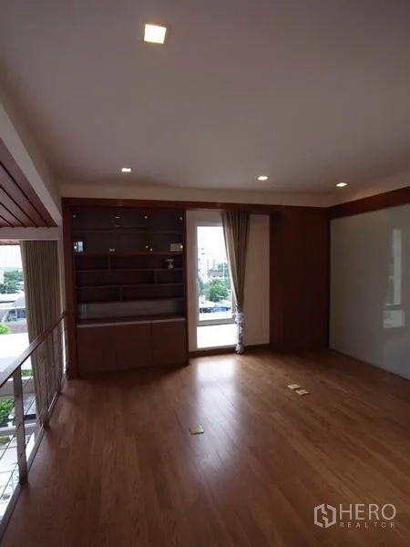 公寓 出租在Chatuchak, Bangkok - 夹层房间，内置木质柜与通往阳台的玻璃门，俯瞰客厅。