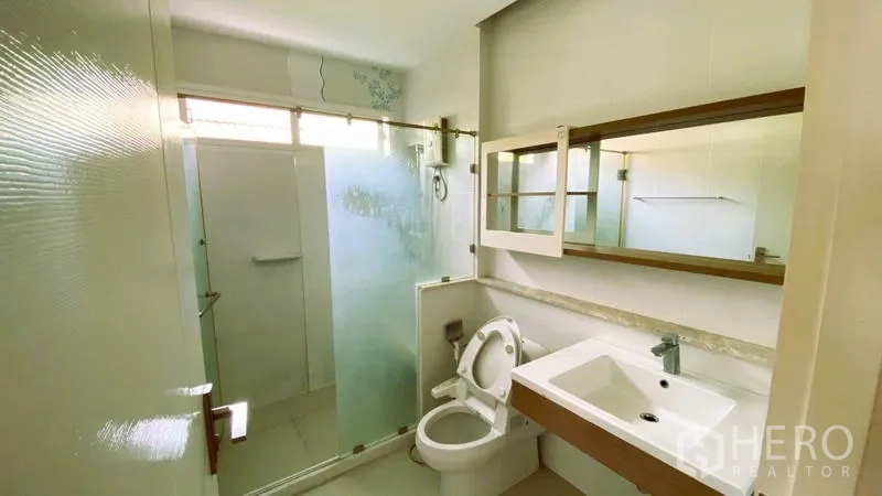Detached House for rent in Bang Kapi, Bangkok - Modern bathroom with vanity, mirror cabinet and glass shower enclosure.