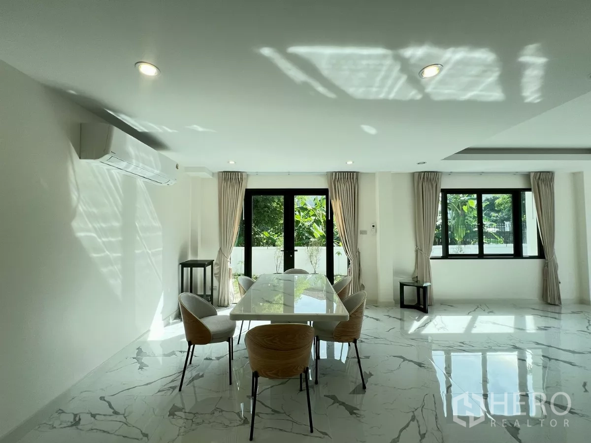 บ้าน ให้เช่าในSuan Luang, Bangkok - พื้นที่ทานอาหารสว่างรับแสงธรรมชาติ มองเห็นสวนผ่านหน้าต่างกรอบสีดำ.