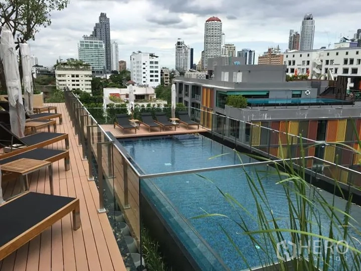 公寓 出租或出售在Watthana, Bangkok - 屋顶游泳池与日光躺椅，俯瞰曼谷天际线