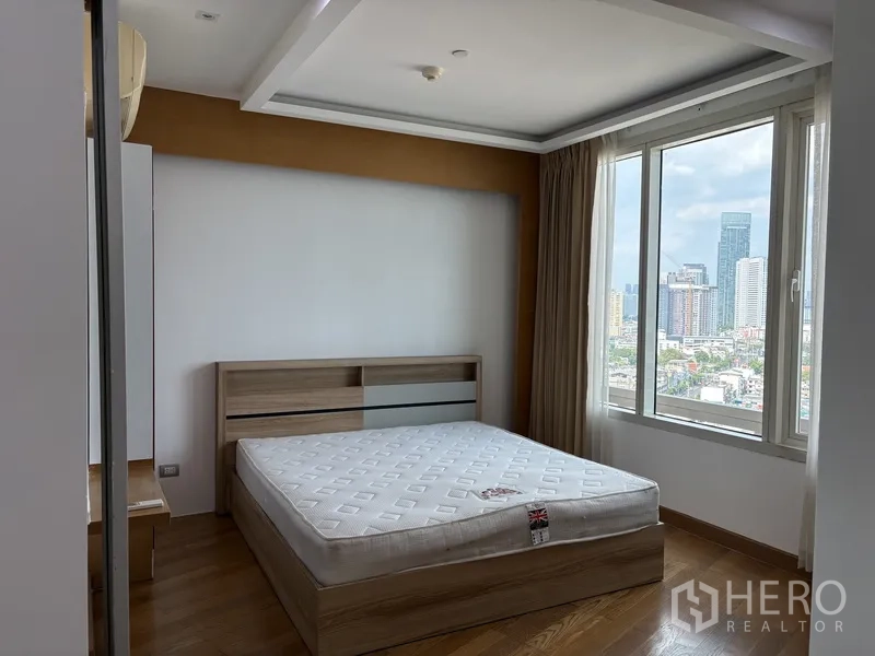 คอนโด for rent in Khlong San, Bangkok - ห้องนอนมุมด้วยหน้าต่างกว้าง วิวเมือง และเตียงลายไม้โทนอ่อน