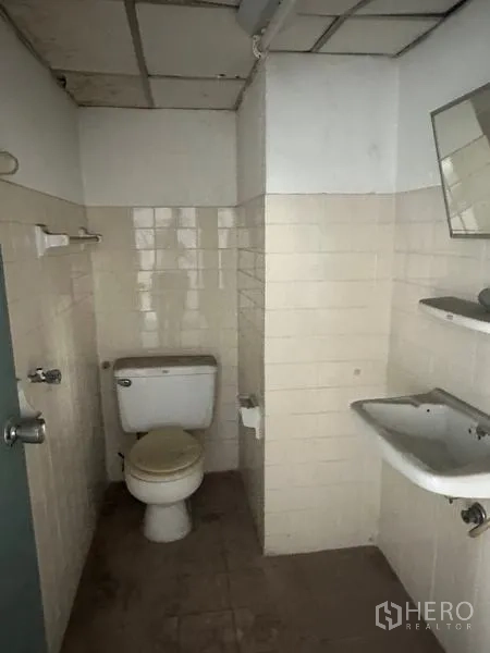 Factory for rent or sale in Khlong Luang, Pathum Thani - Factory restroom with tiled walls, toilet and sink.