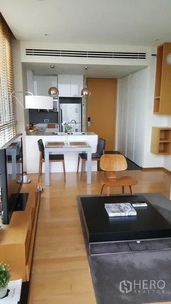 คอนโด ให้เช่าในWatthana, Bangkok - พื้นที่นั่งเล่นและรับประทานอาหารพื้นไม้ พร้อมทีวีและครัวด้านหลัง