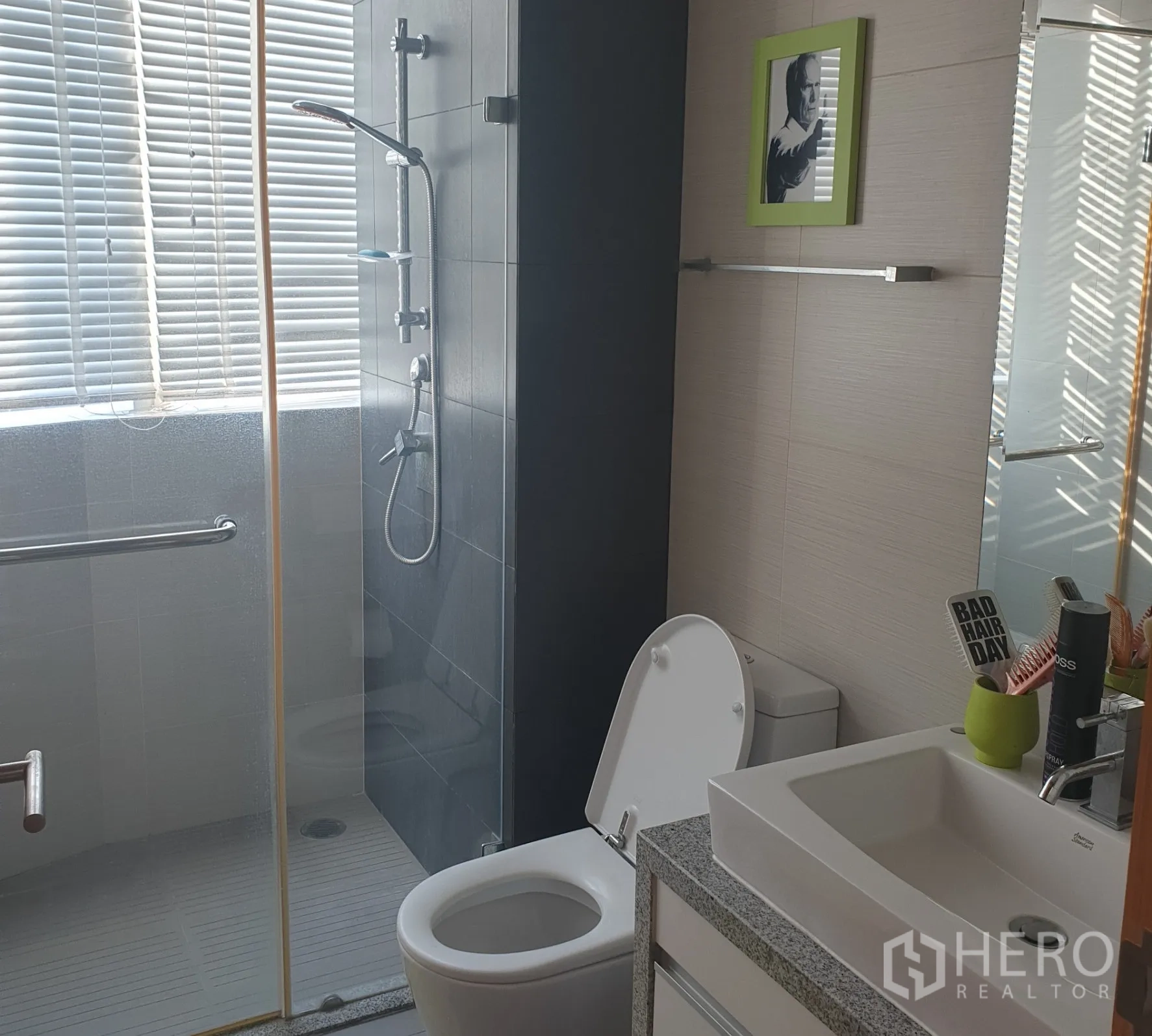 คอนโด ขายในKhlong Toei, Bangkok - ห้องน้ำสว่างมีตู้ฝักบัวกระจก โถสุขภัณฑ์ และอ่างล้างหน้าข้างหน้าต่างบานมู่ลี่