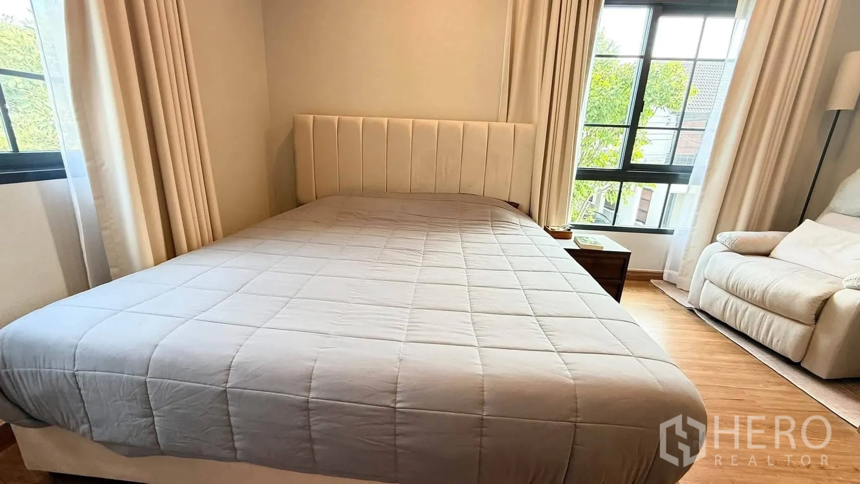 独栋房屋 for rent in Bang Phli, Samut Prakan - 主卧配高靠软包床头，落地窗外可见绿树景观。