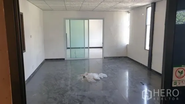 Warehouse for rent in Huai Khwang, Bangkok - Bright office room with tiled floor, sliding glass doors, and narrow vertical windows.