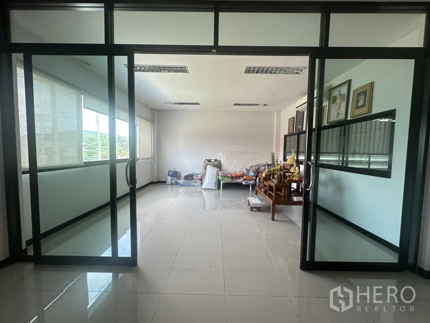 Warehouse for sale in Bang Len, Nakhon Pathom - Glass-partitioned office room with sliding doors and glossy tiled floor.