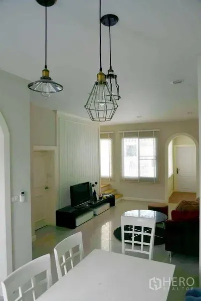 联排别墅 出租或出售在Wang Thonglang, Bangkok - 餐区配吊灯，俯瞰开放式客餐厅空间。