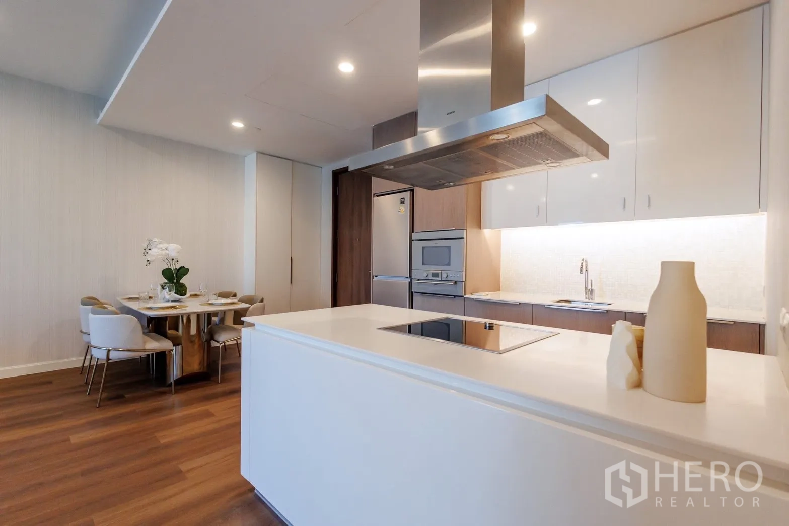 公寓 for rent or sale in Pathum Wan, Bangkok - 开放式厨房，设岛台、嵌入式家电与餐桌。