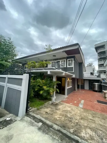 บ้าน ให้เช่าในWatthana, Bangkok - บ้านเดี่ยวสองชั้นสีเทา พร้อมประตูรั้ว ทางเข้าปูอิฐแดงและสวนเขียวชอุ่ม.