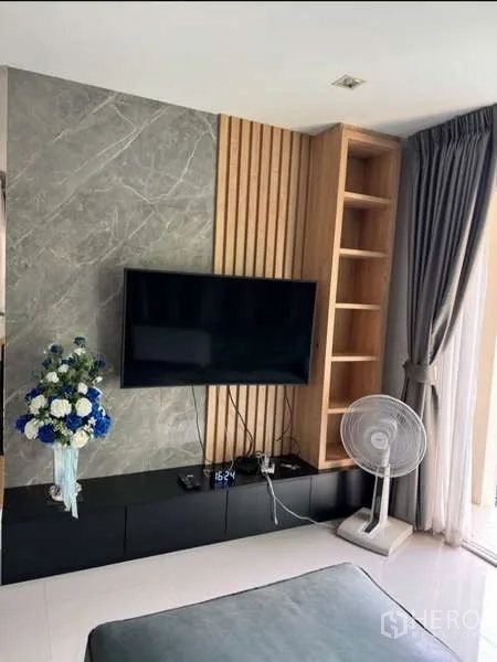 Detached House for rent in Bueng Kum, Bangkok - Close-up of TV feature wall with marble and wood panels plus shelving.