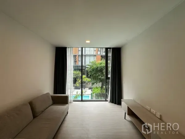 คอนโด ให้เช่าในKhlong Toei, Bangkok - ห้องนั่งเล่นสว่างในคอนโดคลองเตย พร้อมกระจกเต็มบานมองวิวสวนและสระว่ายน้ำ