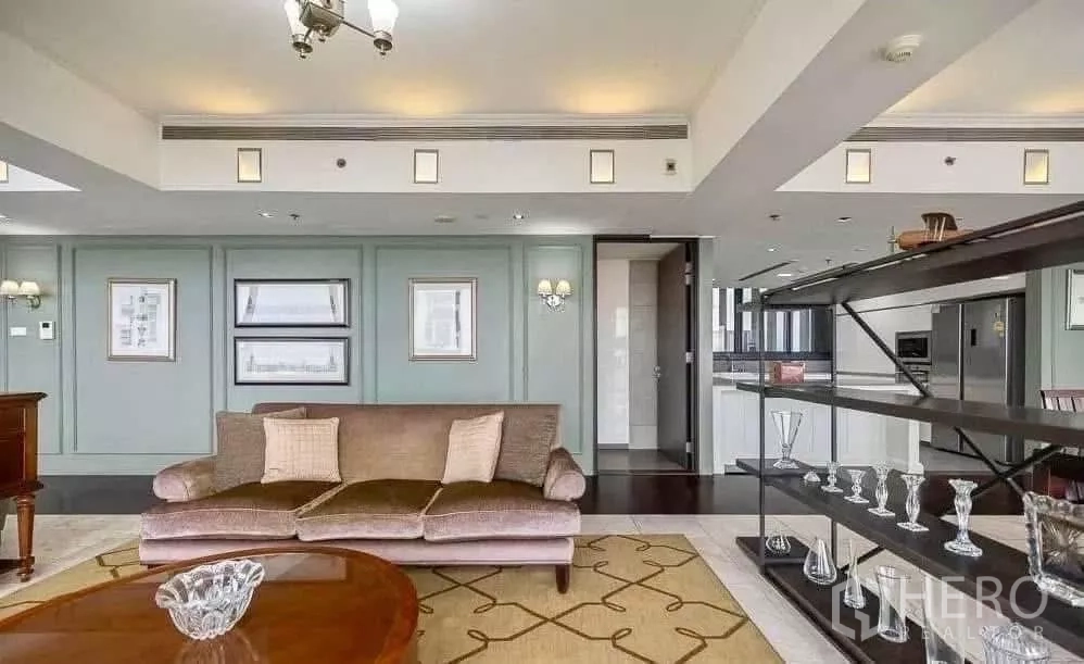 Condominium for rent in Sathon, Bangkok - Elegant lounge with mint wall panelling, open shelving and a glimpse of the modern kitchen.