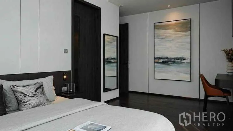 Condominium for rent or sale in Watthana, Bangkok - Bedroom suite with desk, wall art and full-length mirror beside the bed.