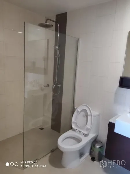 คอนโด ให้เช่าหรือขายในPathum Wan, Bangkok - ห้องน้ำโมเดิร์น พร้อมฝักบัวเรนชาวเวอร์กั้นกระจก ผนังกระเบื้องสีขาว อ่างล้างหน้า และโถสุขภัณฑ์