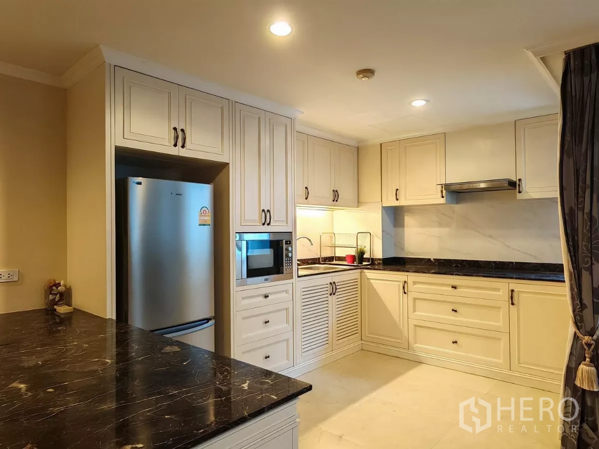 คอนโด ให้เช่าในPathum Wan, Bangkok - ครัวรูปตัวแอล มีเครื่องดูดควัน ตู้สีครีม และท็อปหินอ่อน