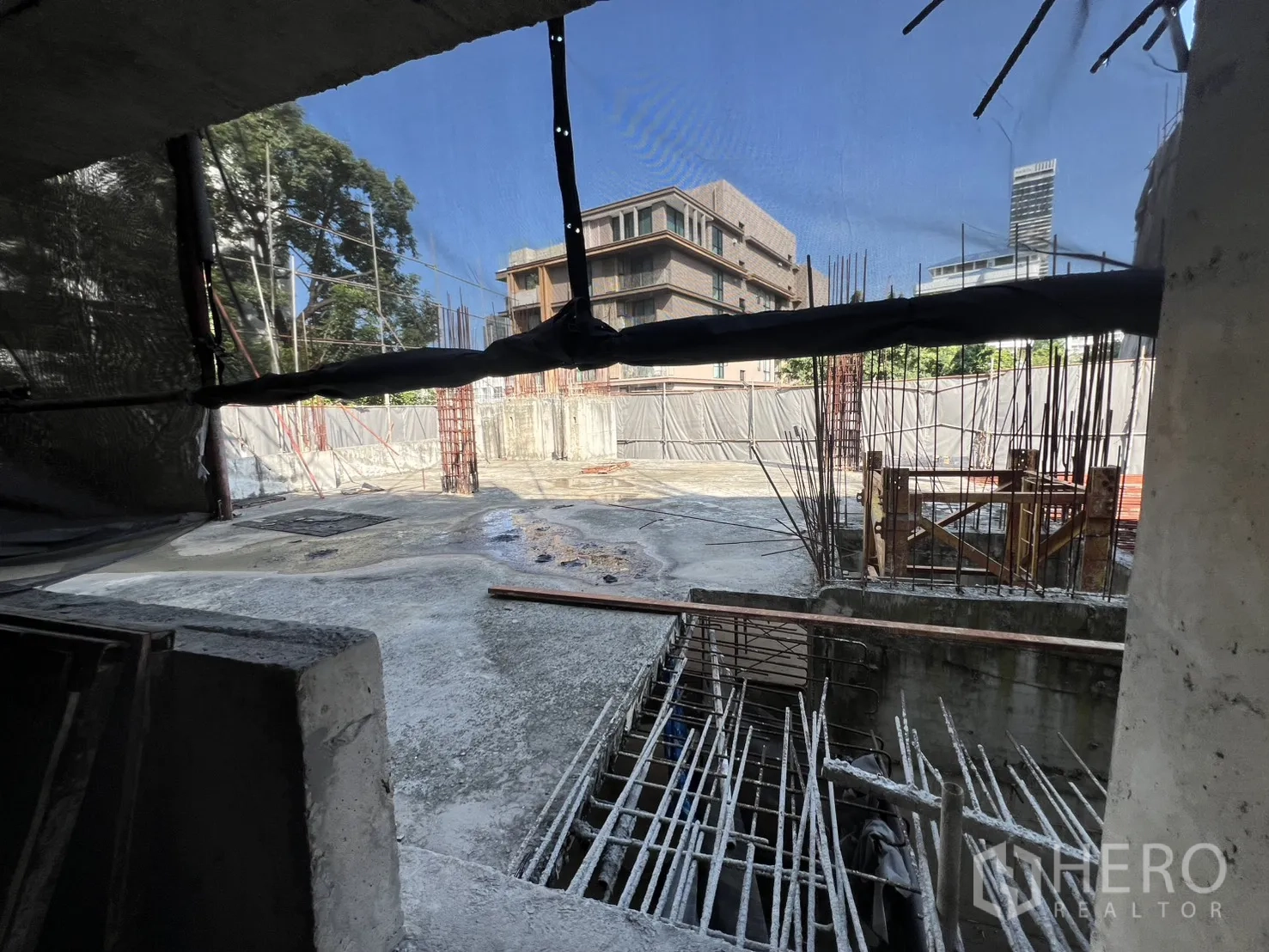 独立商业地产 出售在Watthana, Bangkok - 施工场地，钢筋、脚手架及周边低层建筑。