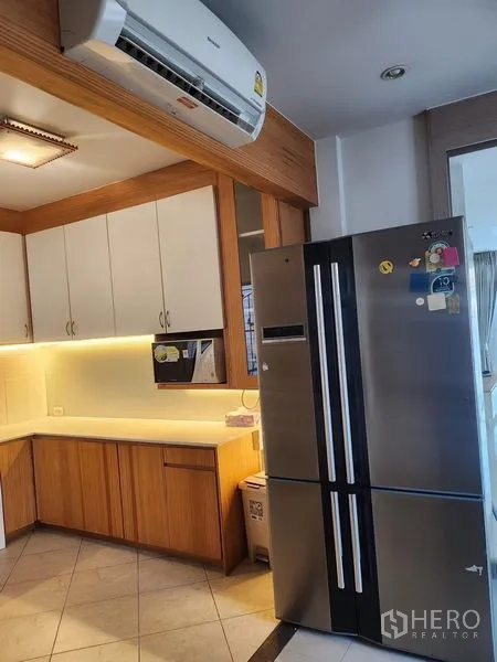 Detached House for rent in Bang Kapi, Bangkok - Kitchen corner featuring a double-door refrigerator and wall-mounted air conditioner.
