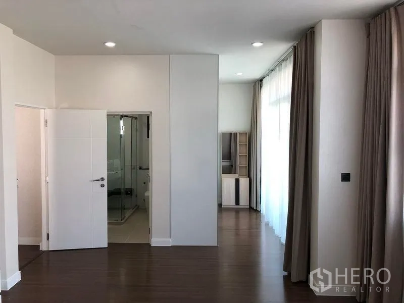 Detached House for rent in Bang Kapi, Bangkok - Spacious master suite with wood floors, full-height curtains and ensuite glass shower.