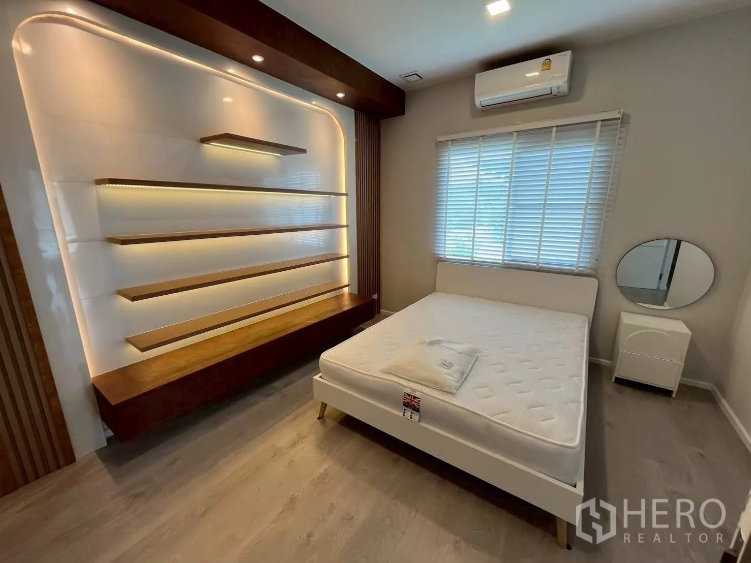 独栋房屋 for rent in Prawet, Bangkok - 卧室内设带灯壁挂层板与白色床。