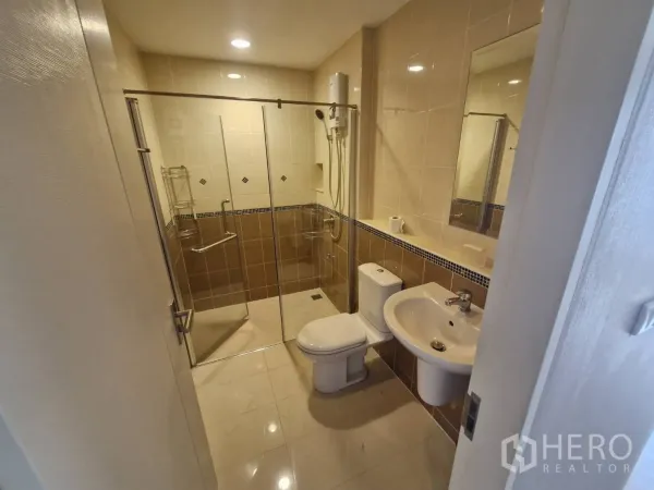 Townhouse for sale in Rat Burana, Bangkok - Modern bathroom with glass-enclosed shower, toilet, and vanity.