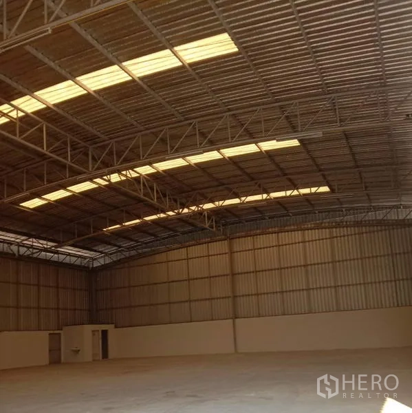 货栈 出租在Lat Krabang, Bangkok - 宽敞仓库内部，高钢结构屋顶配采光带与平整混凝土地面。