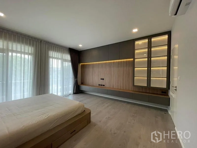 บ้าน ให้เช่าในPrawet, Bangkok - ผนังตู้บิลท์อินห้องนอนใหญ่ พร้อมชั้นโชว์ไฟส่องสว่างและลายไม้โทนอุ่น