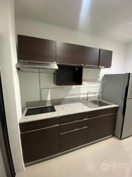 บ้าน ให้เช่าหรือขายในSaphan Sung, Bangkok - ครัวบิวท์อินตู้สีเข้ม เคาน์เตอร์หิน เตา และอ่างล้างจานสแตนเลส