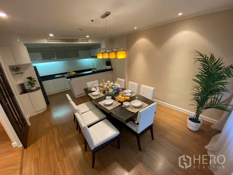 อพาร์ทเมนท์ ให้เช่าในWatthana, Bangkok - ห้องรับประทานอาหารโต๊ะ 8 ที่นั่ง โคมไฟห้อยคู่ กับครัวเปิดในอพาร์ตเมนต์ย่านเอกมัย