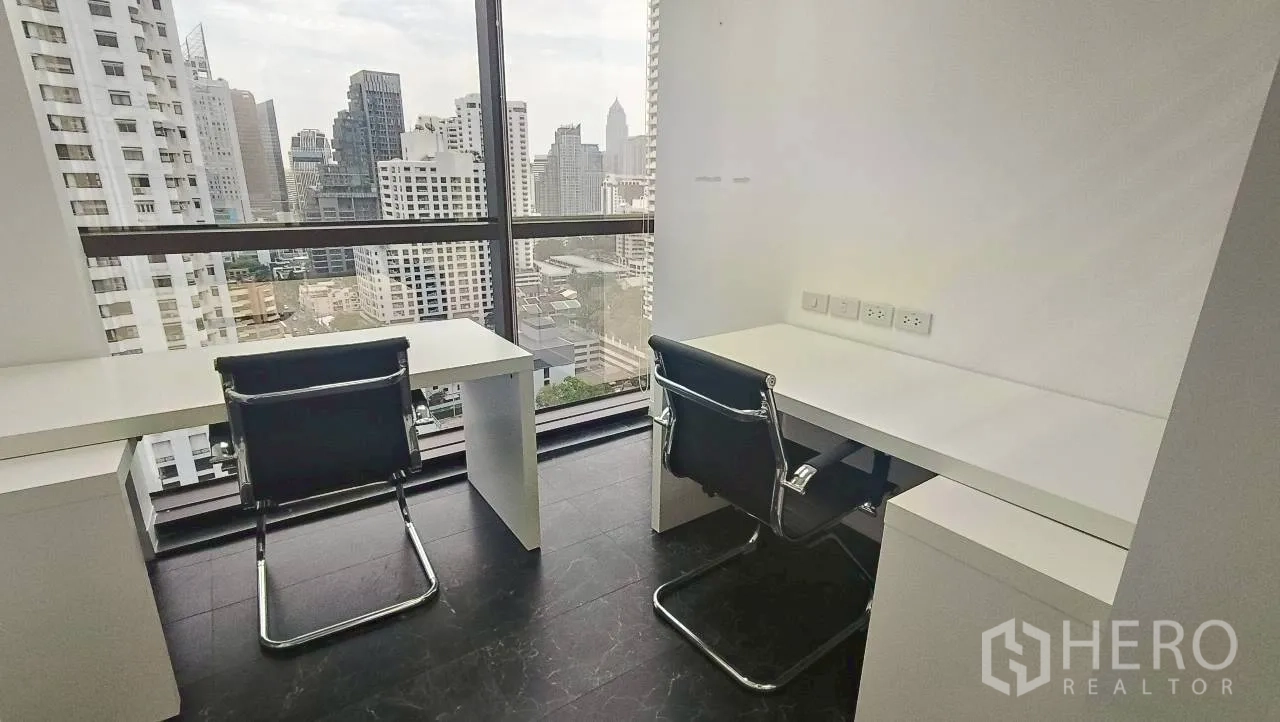 ออฟฟิศ for rent in Ratchathewi, Bangkok - โต๊ะทำงานสองตัวริมหน้าต่างเห็นสกายไลน์ชัดเจน.