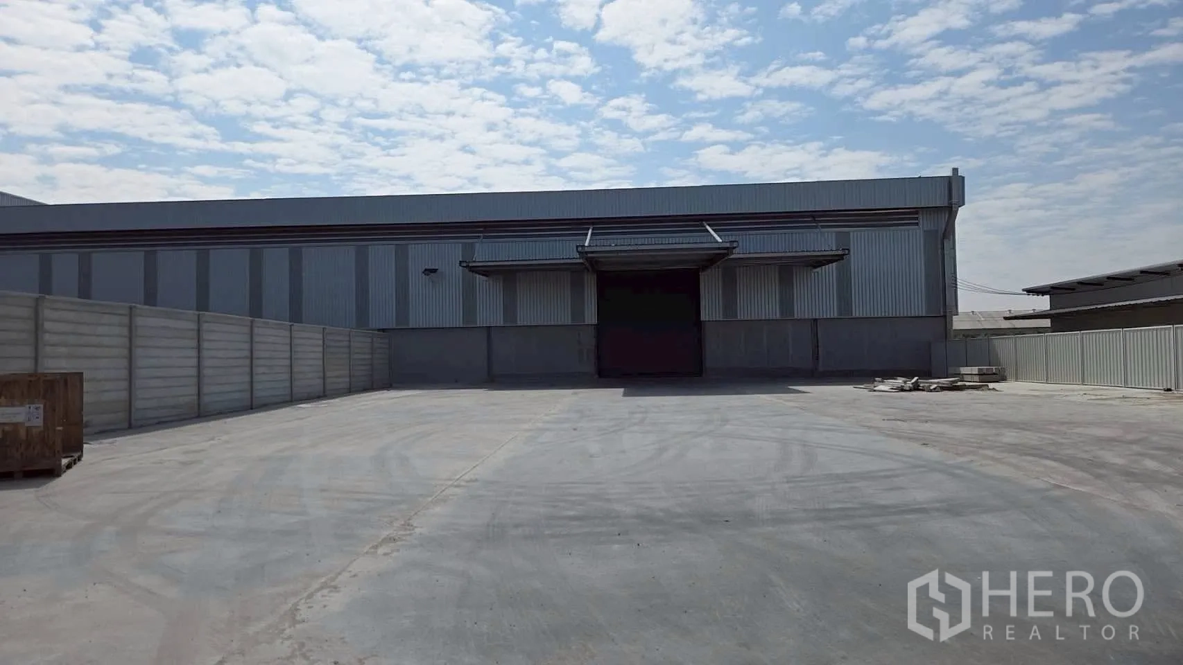 Warehouse for rent in Bang Bo, Samut Prakan - Gated concrete yard in front of the warehouse with loading bay access.
