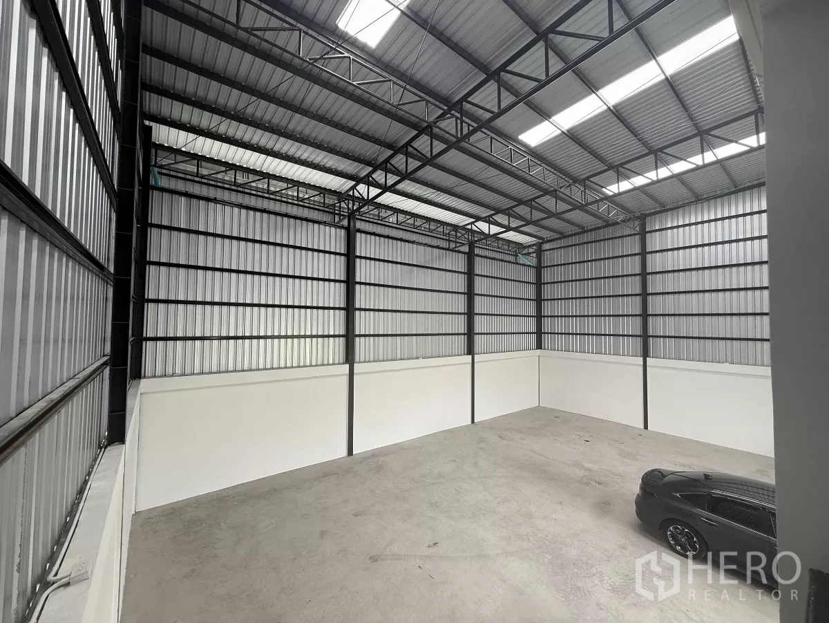 Warehouse for rent in Lat Krabang, Bangkok - Tall warehouse bay showing steel trusses, skylight panels and smooth concrete floor.