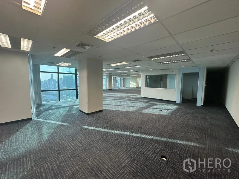 Office Space for rent in Watthana, Bangkok - Spacious office level with grid ceiling lights, columns, and internal glass partition.