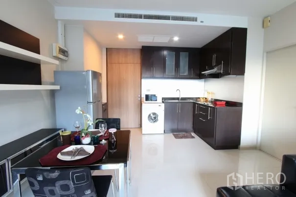 คอนโด ให้เช่าในWatthana, Bangkok - ครัวและมุมทานข้าวแบบเปิด ตู้ลายไม้สีเข้ม ตู้เย็นและเครื่องซักผ้า ภายในคอนโดสไตล์ทองหล่อ