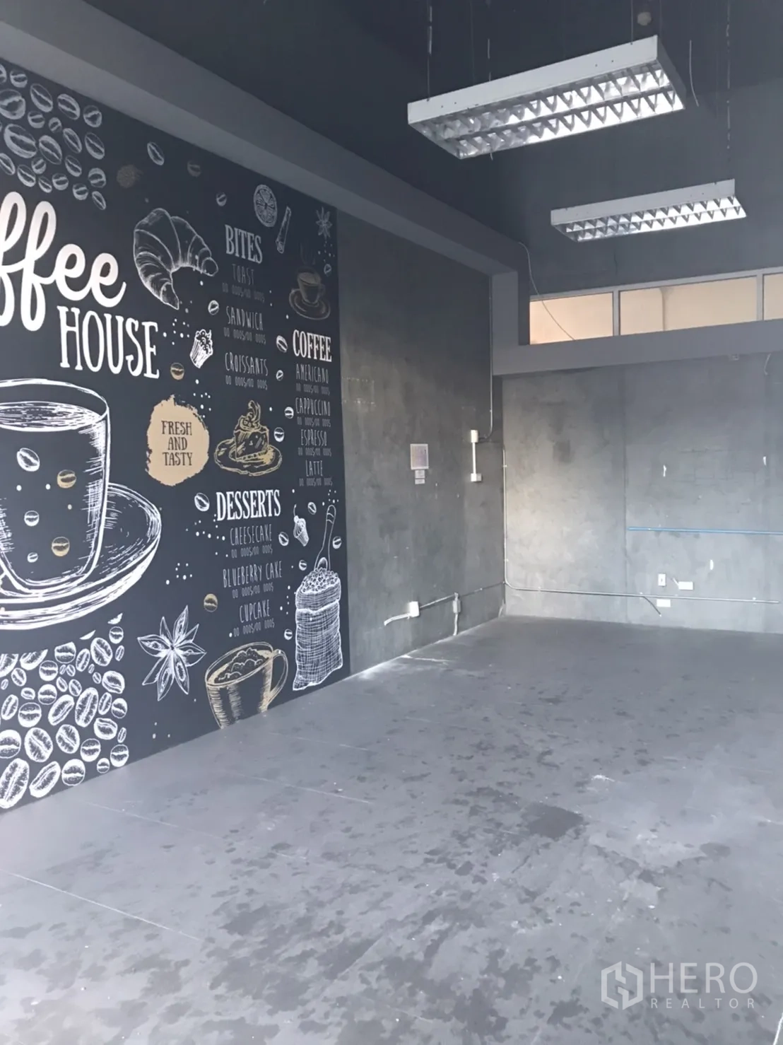 零售空间 出租在Khlong Toei, Bangkok - 工业风店内，咖啡馆风格黑板墙，预留电位与悬挂日光灯，便于设备安装。