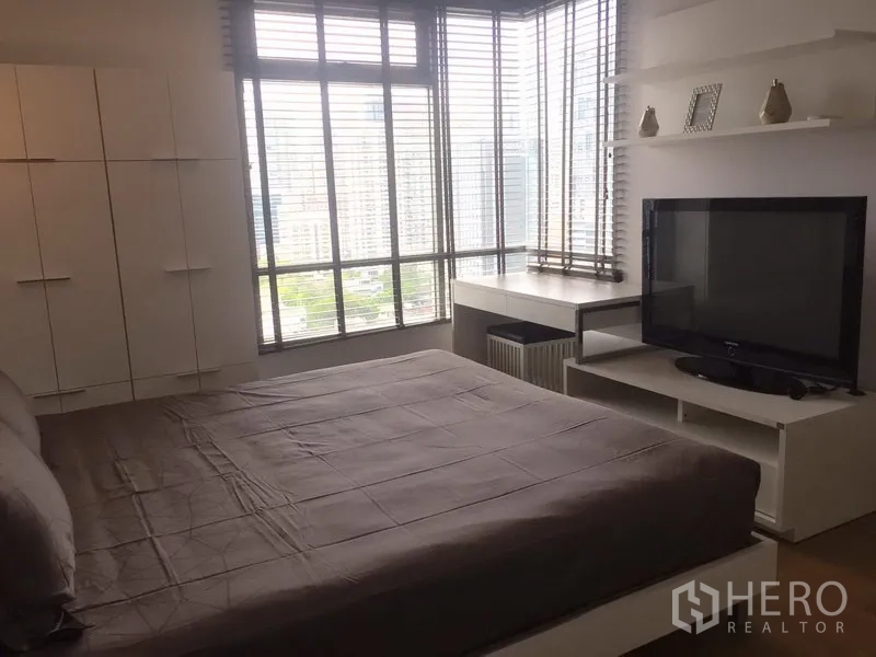 คอนโด ให้เช่าในWatthana, Bangkok - ห้องนอนมุมอาคาร มองเห็นวิวเมืองกว้าง พร้อมชั้นทีวีและโต๊ะทำงานบิวท์อิน