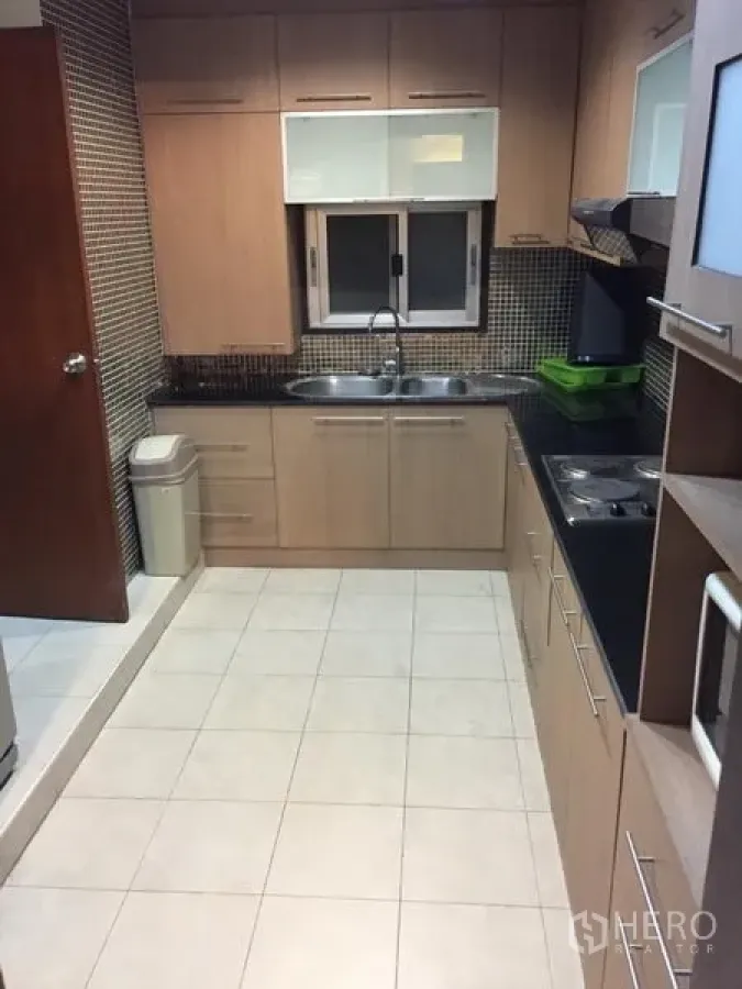 公寓 出租在Khlong Toei, Bangkok - 木色橱柜与黑色花岗岩台面的封闭式厨房，马赛克墙面与双水槽