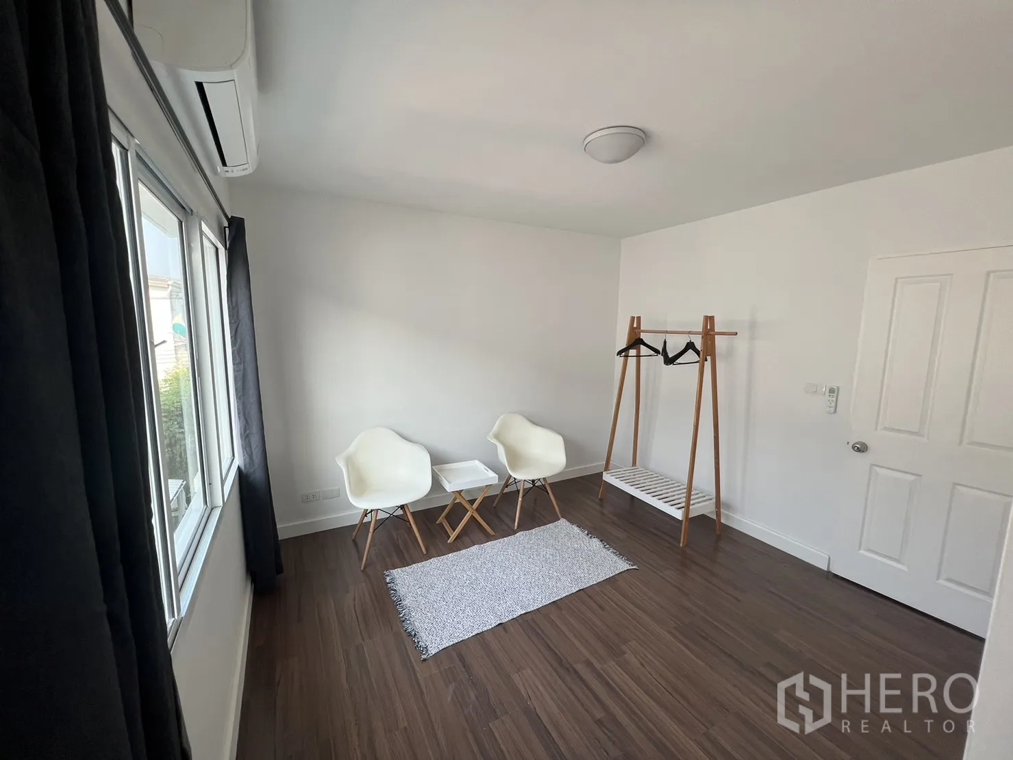 ทาวน์เฮาส์ for rent in Suan Luang, Bangkok - ห้องสว่างโล่งมีเก้าอี้สองตัวและราวแขวนเสื้อแบบตั้งพื้น.