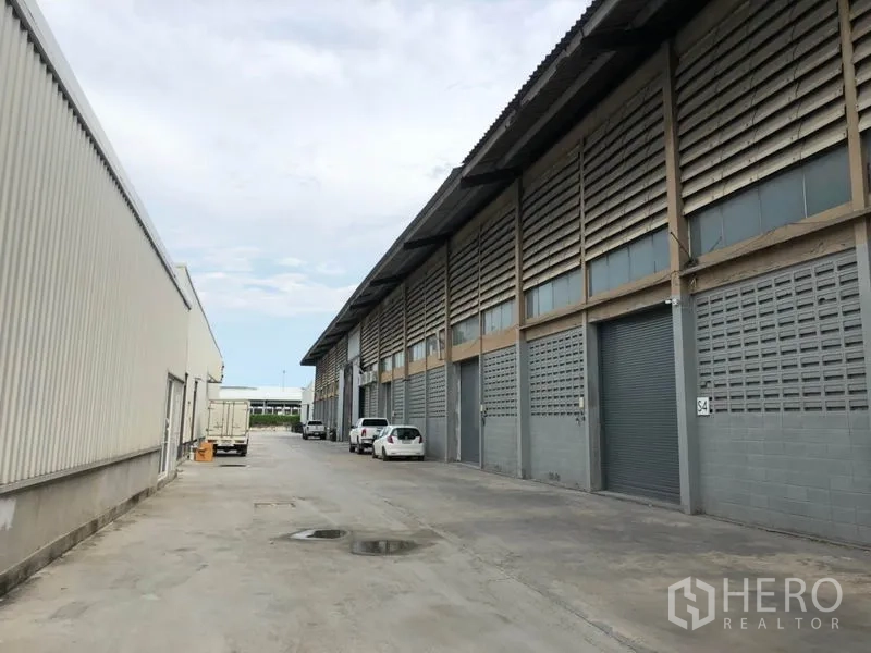 โรงงาน ให้เช่าในMueang Samut Prakan, Samut Prakan - ด้านหน้าอาคารอุตสาหกรรม ประตูม้วน และถนนกว้างสำหรับรถบรรทุก