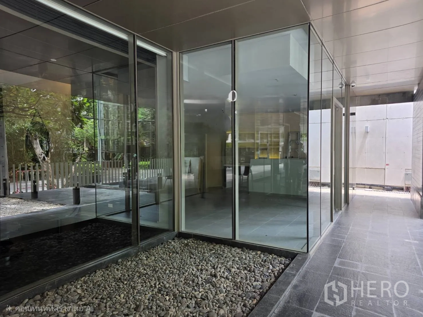 Retail Space for rent in Khlong Toei, Bangkok - Corner glass facade beside a pebbled landscape and walkway.