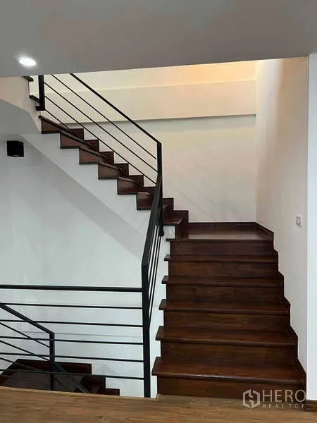 Home Office for rent in Bueng Kum, Bangkok - Dark wood staircase with black metal railings connecting multiple levels.