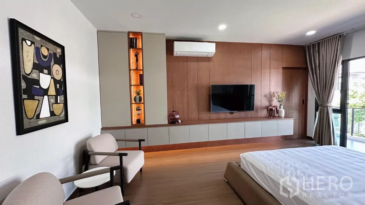 Detached House for rent in Bang Phli, Samut Prakan - Master suite seating area with TV wall and lit display shelves.