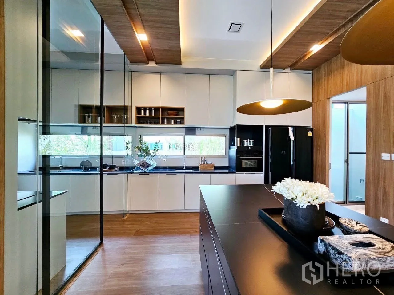 บ้าน ให้เช่าในSaphan Sung, Bangkok - ครัวกั้นกระจกพร้อมเครื่องใช้สีดำและถาดบนไอส์แลนด์