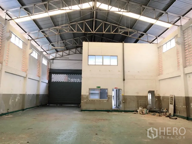 โรงงาน ให้เช่าในPathum Thani - คลังสินค้าเพดานสูง โครงหลังคาเหล็ก มีบล็อกออฟฟิศภายในและประตูม้วนขนาดใหญ่