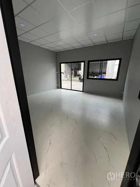 Warehouse for rent in Phra Samut Chedi, Samut Prakan - Bright office room inside the warehouse with tiled floor, suspended ceiling, and sliding glass doors opening to the yard.