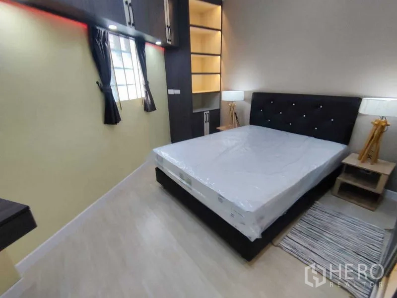 คอนโด ให้เช่าในKhlong Toei, Bangkok - ห้องนอนใหญ่พร้อมหัวเตียงบุผ้า โคมไฟข้างเตียง และชั้นเก็บของมีไฟ