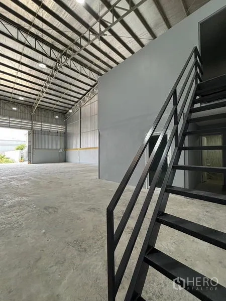 货栈 出租在Mueang Pathum Thani, Pathum Thani - 办公区旁的楼梯通往二层，屋顶挑高。
