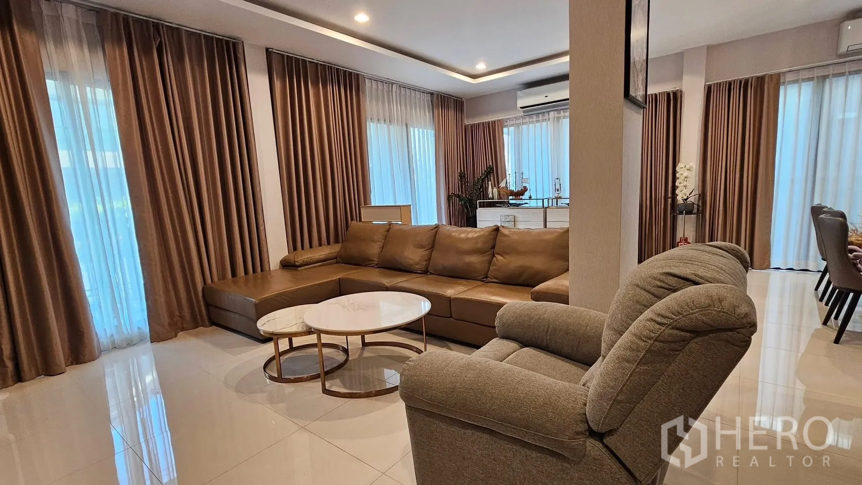บ้านเดี่ยว for rent in Saphan Sung, Bangkok - พื้นที่นั่งเล่น–ทานอาหารกว้าง โซฟารูปตัวแอลและเก้าอี้ใกล้หน้าต่างสูง.