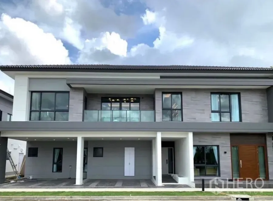 Detached House for sale in Bang Phli, Samut Prakan - Modern two-storey house exterior with balcony, large windows and covered parking.